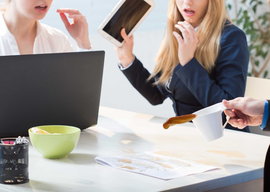 Person spilling coffee in a café under others’ gaze