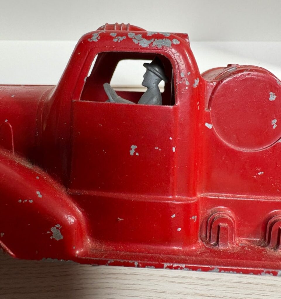  close up firefighter figure inside vintage fire truck toy