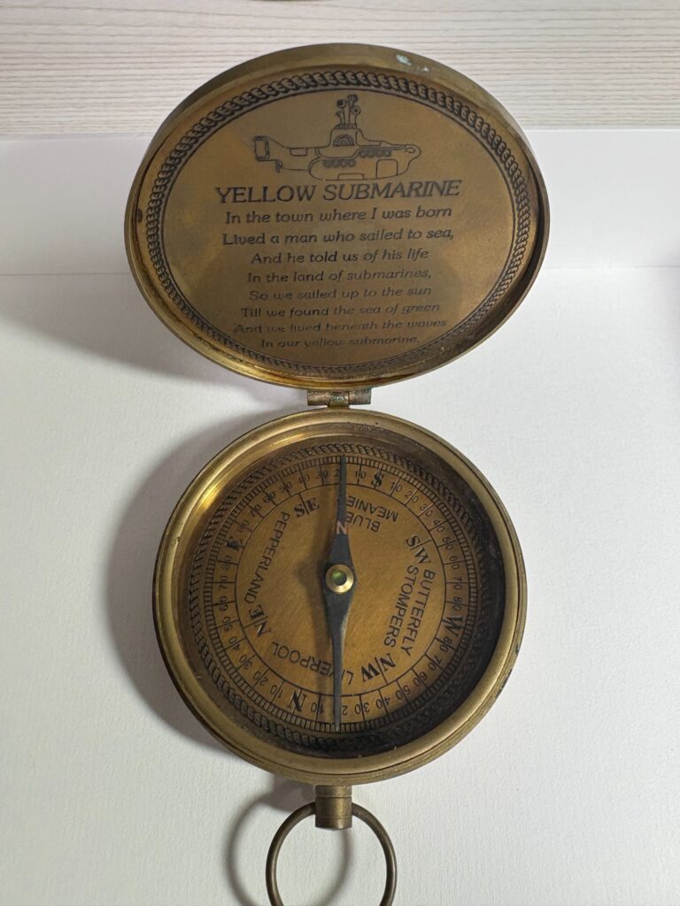 vintage compass dial inside Yellow Submarine brass compass pointing direction