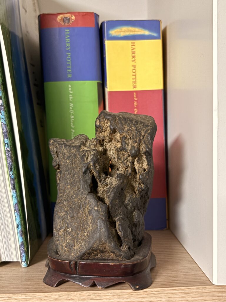 naturally shaped viewing stone displayed on a bookshelf