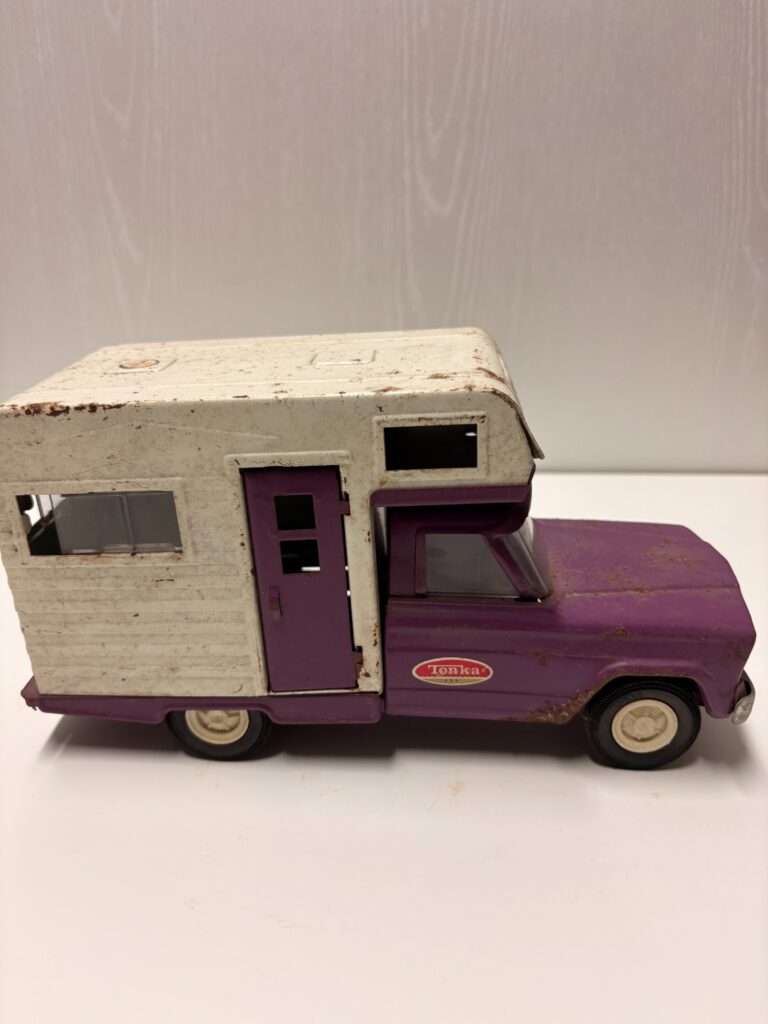 door and windows on the weathered side of a vintage Tonka camper