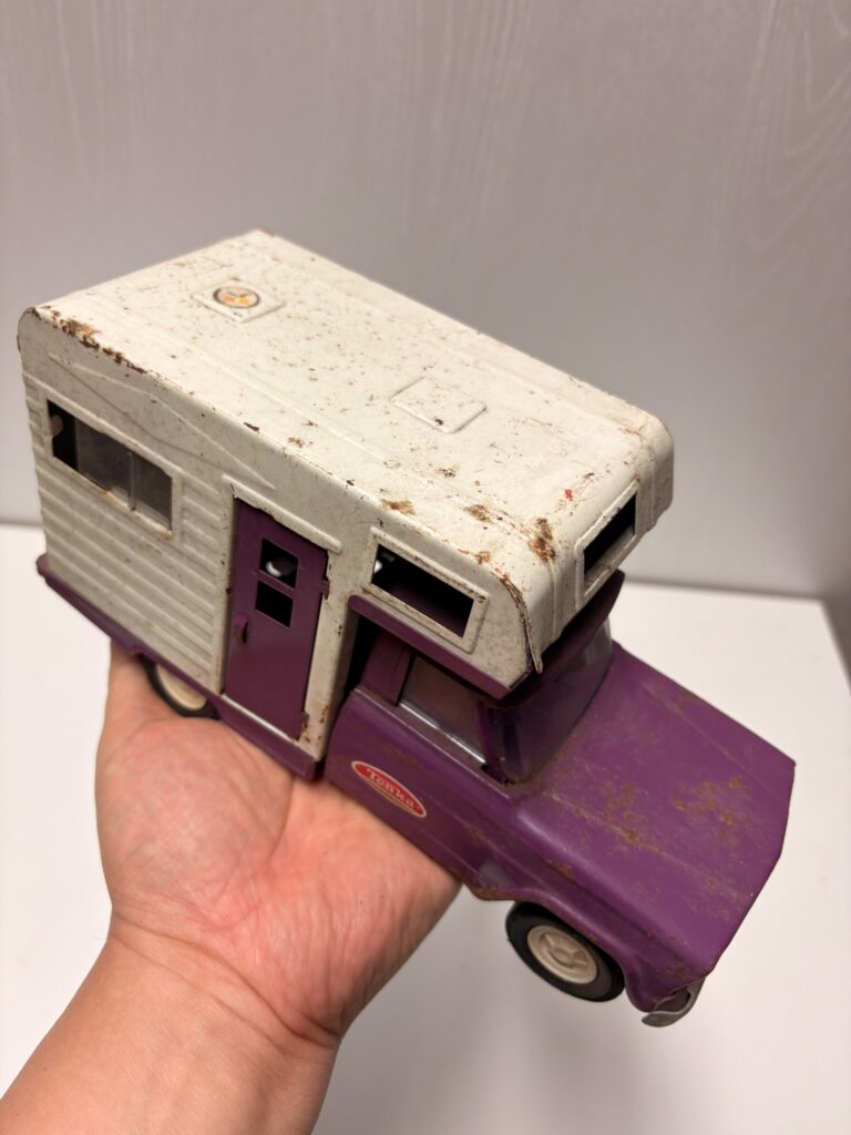 vintage Tonka camper toy resting in a hand
