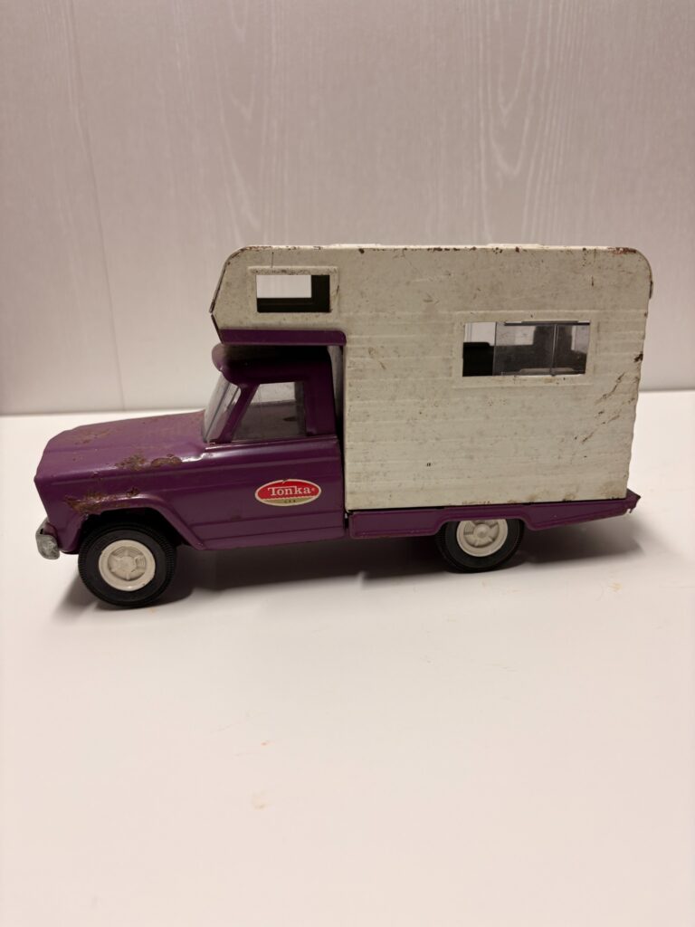 side view of a vintage purple and white Tonka camper toy